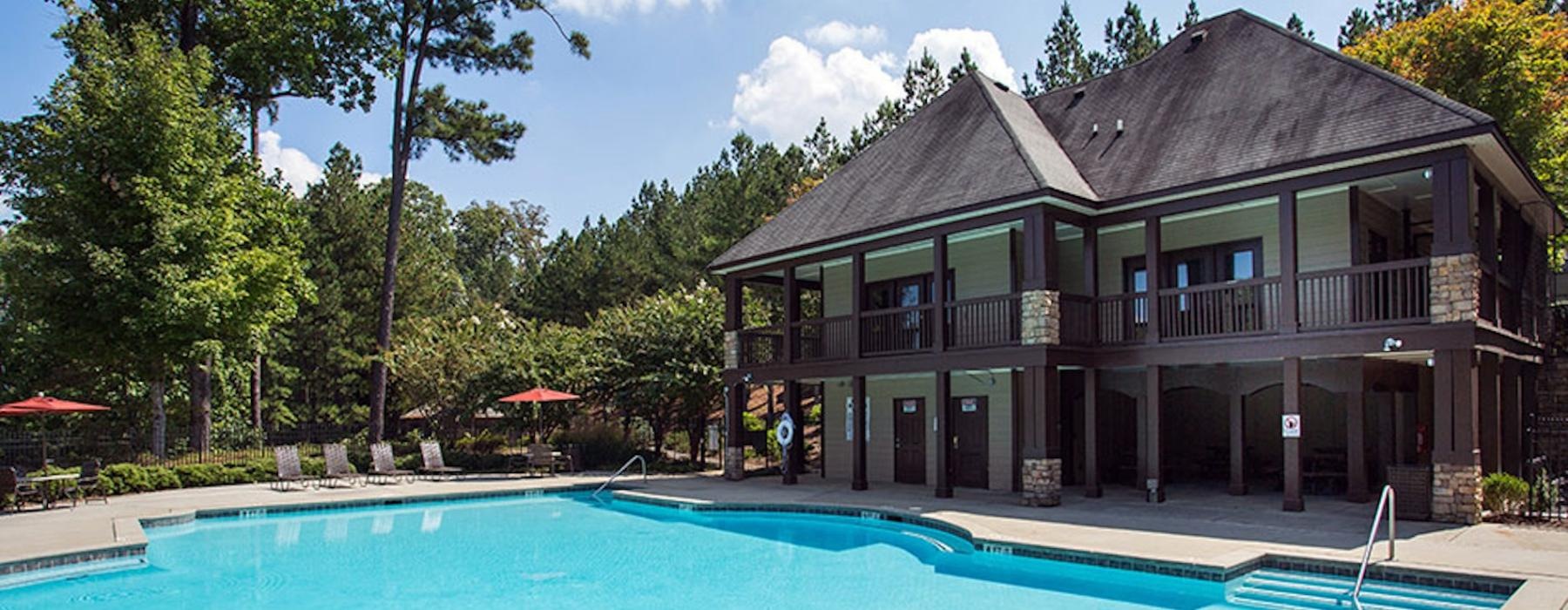 a clubhouse with a pool in front