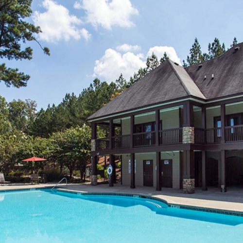 a clubhouse with a pool in the front